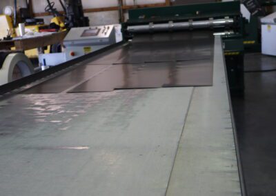 Industrial workshop with large printing machinery and a worn worktable.